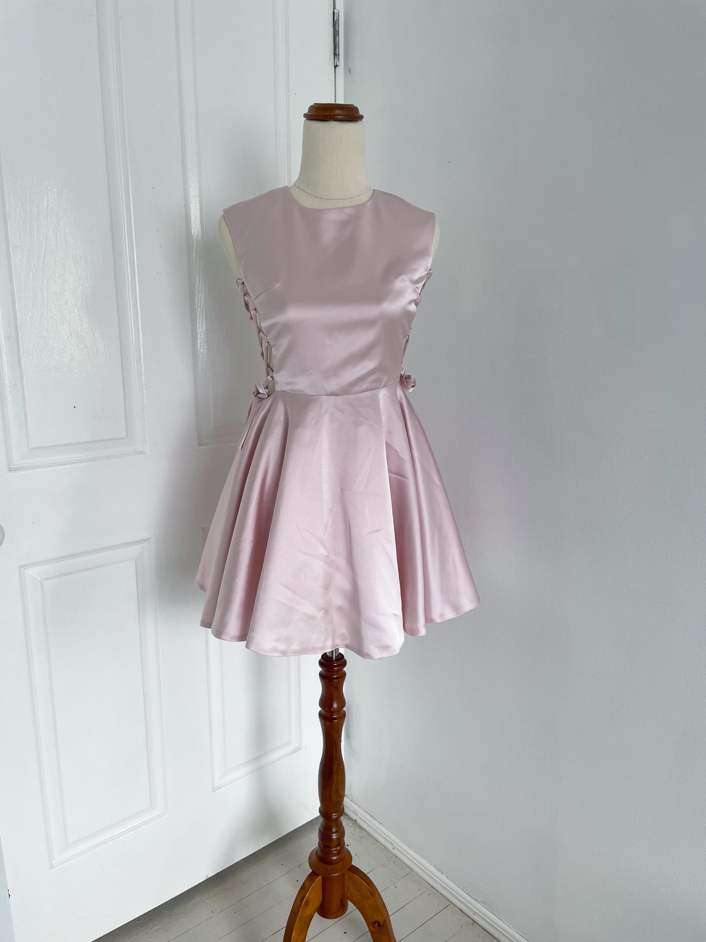 front view of A pink ballerina inspired mini dress with corset sides