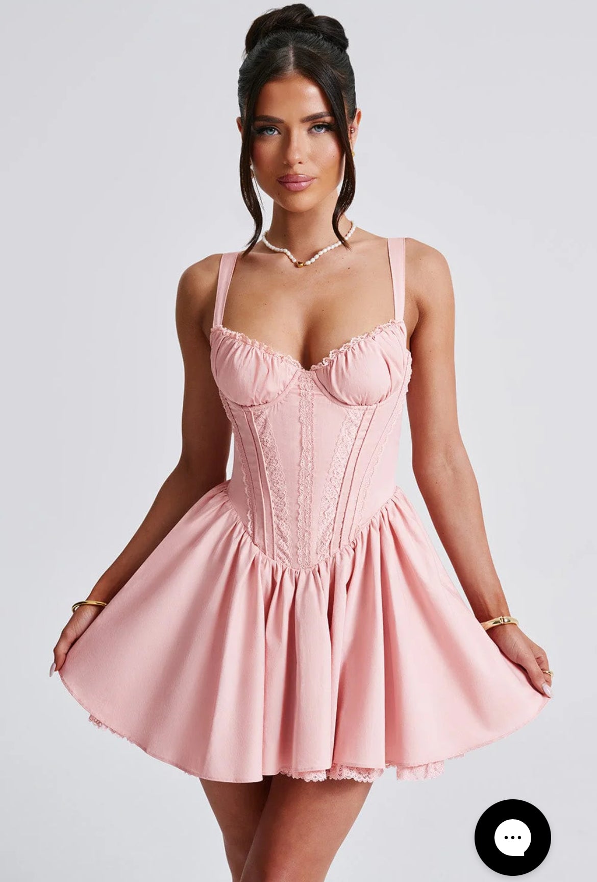 Woman wearing a pink dress against a plain background