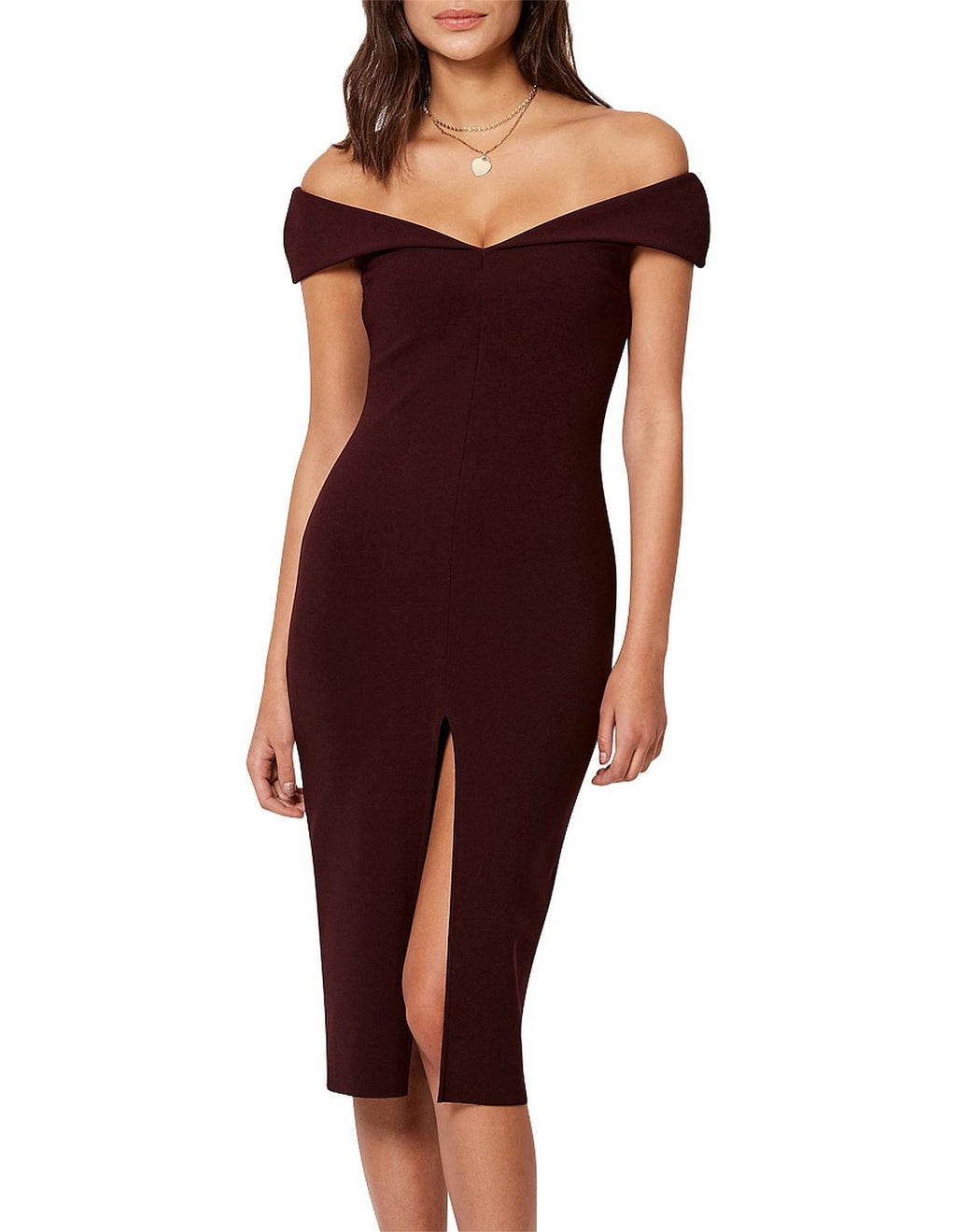 Model wearing the Bec & Bridge Cindy dress, a sophisticated and exclusive midi-length piece in a rich, dark burgundy. With an alluring off-the-shoulder neckline and a seductive side slit.
