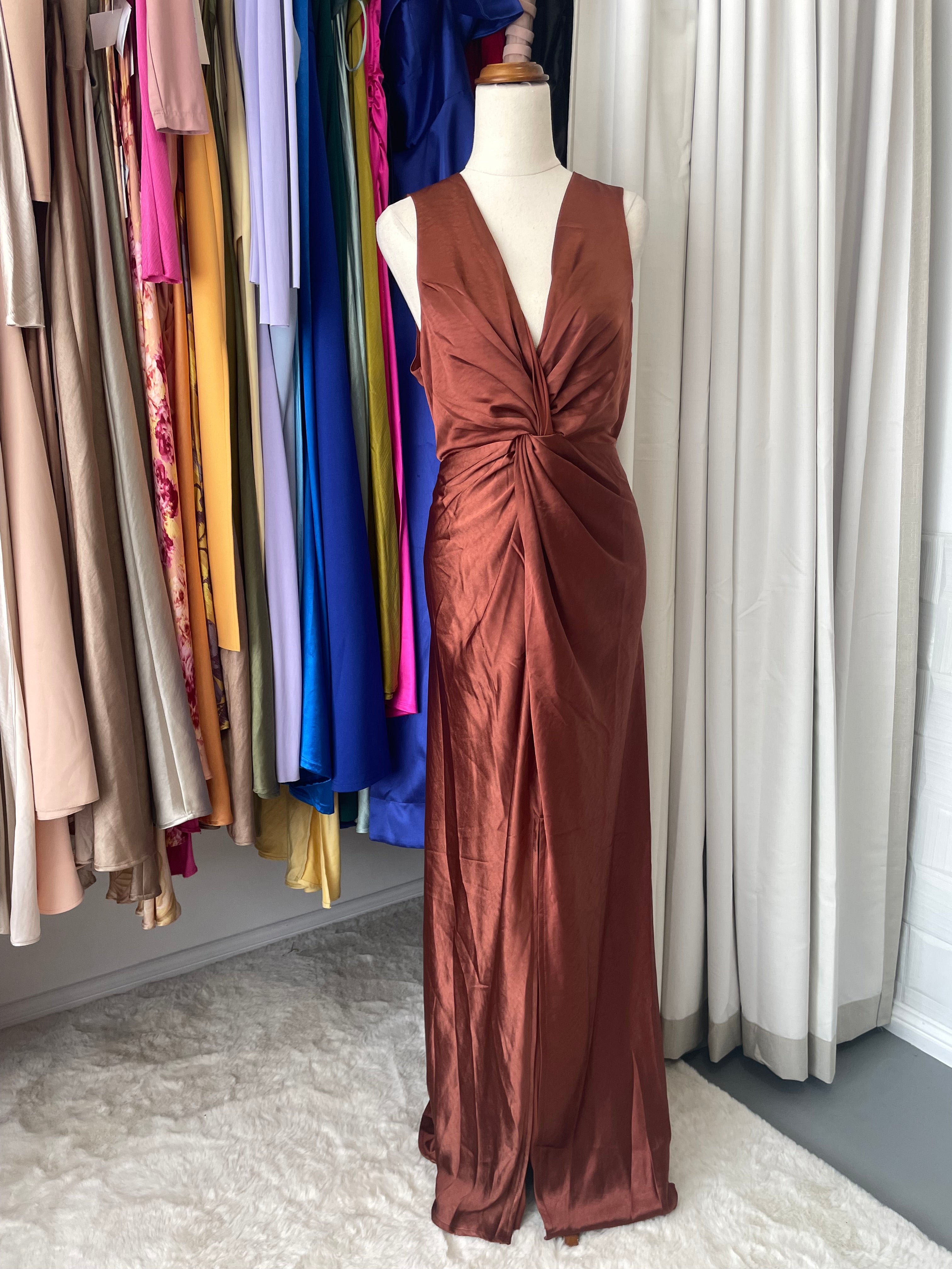 Billy J maxi dress features a flattering V neckline and sophisticated twist detailing at the bust. Supported by sturdy shoulder straps and finished with an invisible back zipper for seamless styling, the design includes a practical front split and full lining for comfort and confidence.