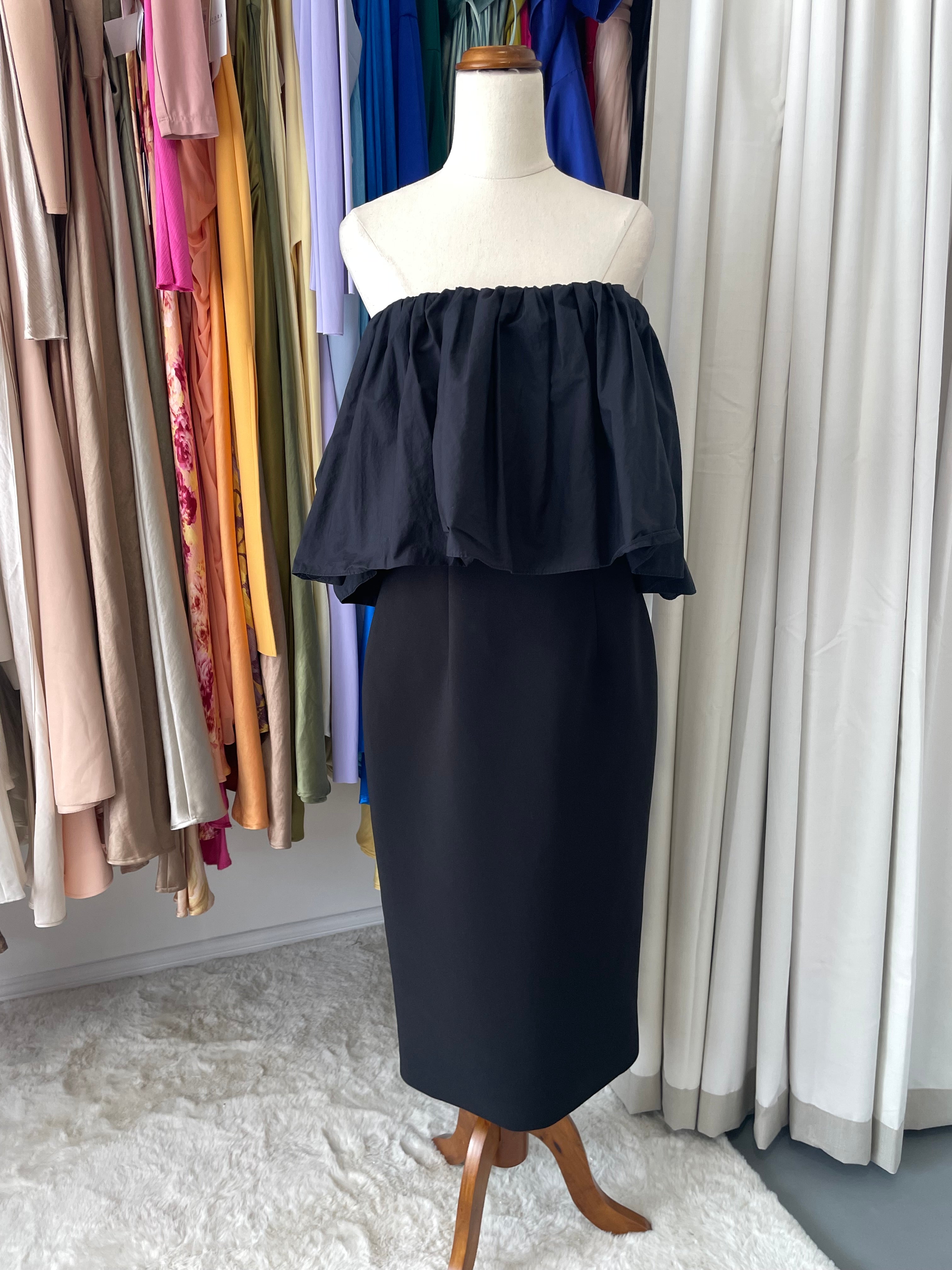 black strapless dress in front of colourful fabric 