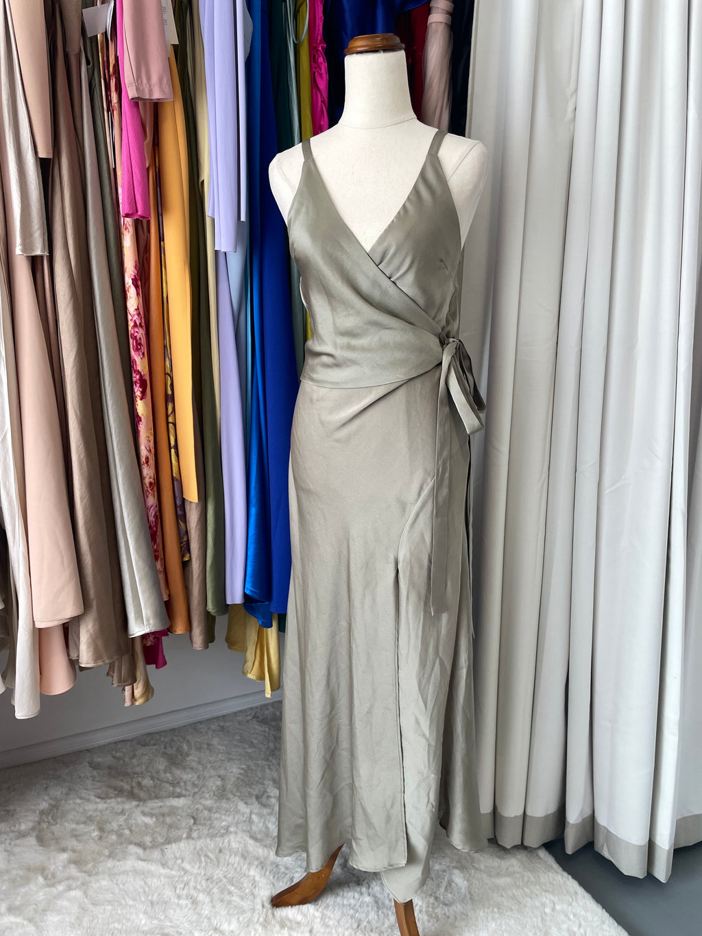 A mannequin wearing an olive green wrap dress front view 