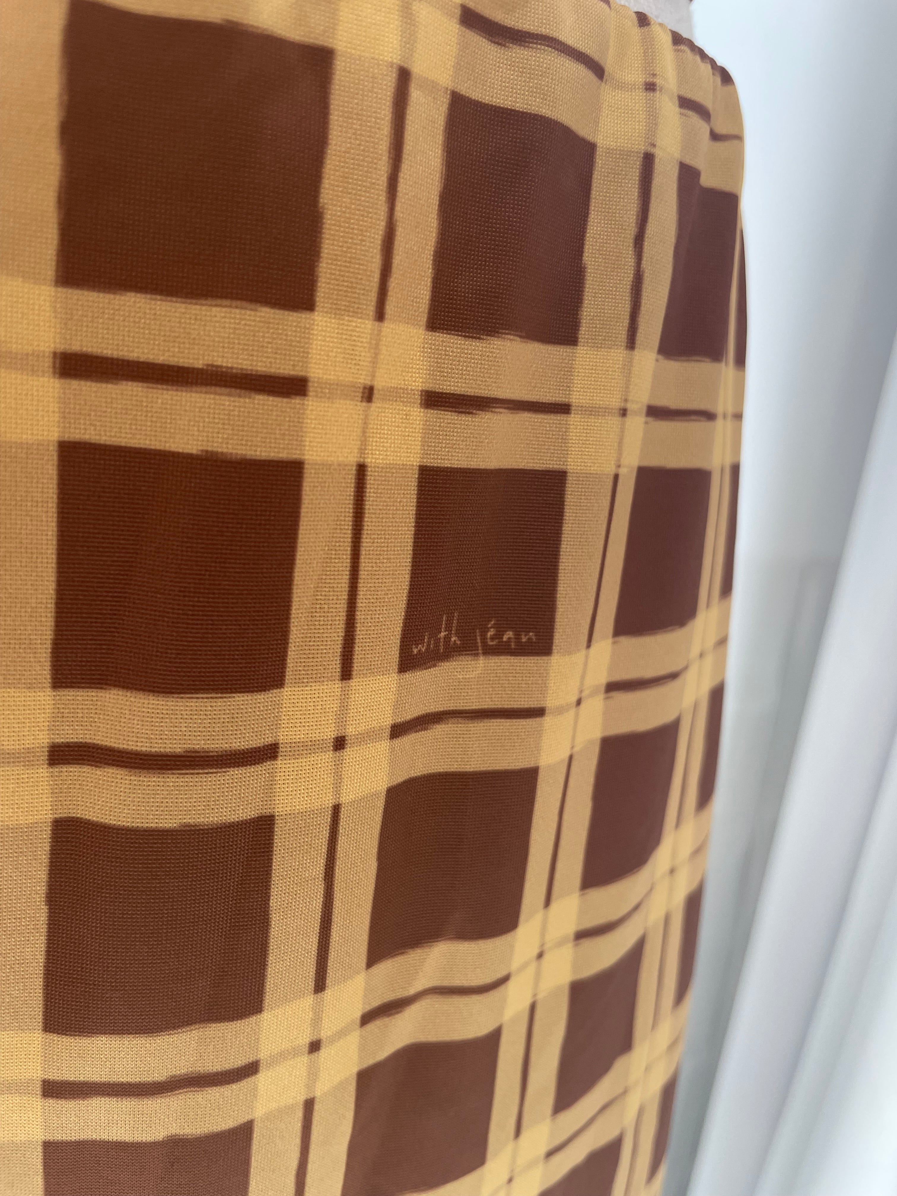Brown and beige checkered fabric with a brand name on a white background