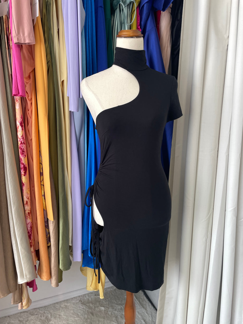 Stack of colorful fabric swatches with a black fabric swatch on top.