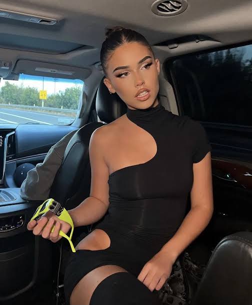 Woman in a black dress sitting inside a car